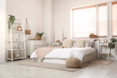 Büyük, rahat bir yatak odası ve pencerenin yanındaki komodinlerde.