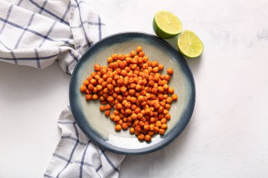 Lezzetli kızarmış nohut ve beyaz arka planda limon tabağı.