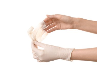 Kadın doktor, beyaz arka planda ellerinden tıbbi eldiven alıyor.