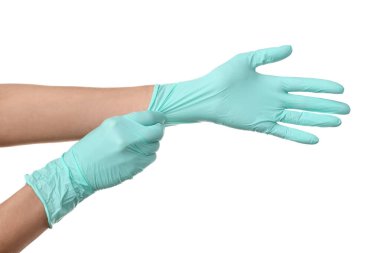 Kadın doktor beyaz arka plana karşı ellerine tıbbi eldiven takıyor.