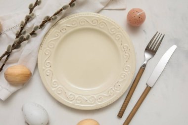 Beautiful table setting with Easter eggs and pussy willow branches on white background