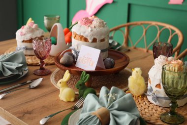 Paskalya pastaları, boyanmış yumurtalar ve Paskalya kutlaması için tebrik kartlarıyla güzel bir masa. Yakın çekim.