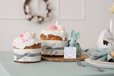 Paskalya pastası, dekoratif tavşan ve Paskalya kutlaması için servis edilen masada tebrik kartı. Yakın çekim.