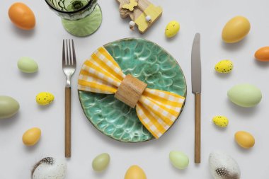 Paskalya yumurtaları ve gri arka planda ahşap tavşanla güzel bir masa.