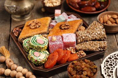 Tahta masadaki Ramazan kutlamaları için lezzetli Doğu tatlılarıyla dolu bir pano.