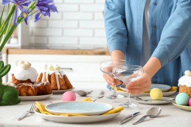 Mutfaktaki Paskalya kutlaması için masaya gözlük koyan kadın. Yakın çekim.