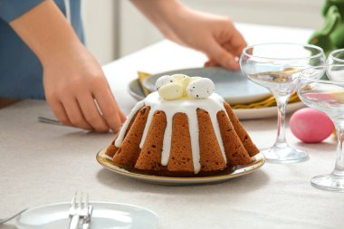 Mutfakta Paskalya pastası ile masa dekorasyonu yapan kadın. Yakın çekim.