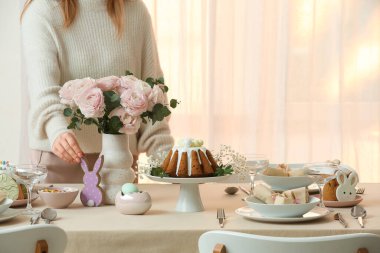 Paskalya tavşanlı kadın Paskalya kutlaması için masada bekliyor. Yakın çekim.