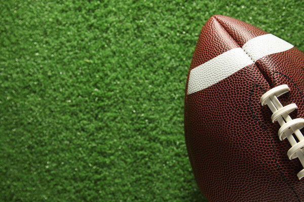Мяч для регби на зеленом фоне травы, крупный план