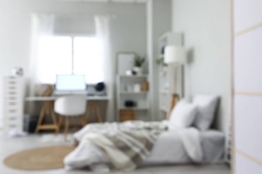 Yatağı, raf üniteleri ve işyeri olan ergen odasının bulanık görüntüsü