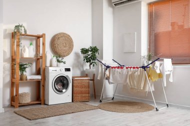 Çamaşır makinesi, raf ünitesi ve kurutuculu çamaşır odasının içi.