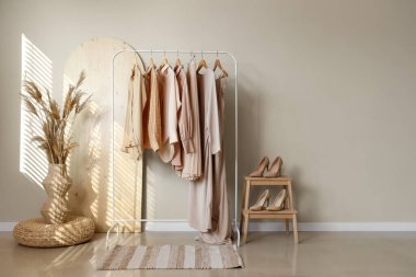 Butiğin içinde giysi askılığı, yüksek topuklu ayakkabılar ve otlar var.