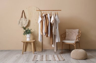 Butiğin içinde elbise askılığı, masa ve koltuk var.