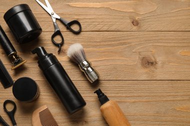 Ahşap arka planda modern budayıcı ve tıraş aksesuarları
