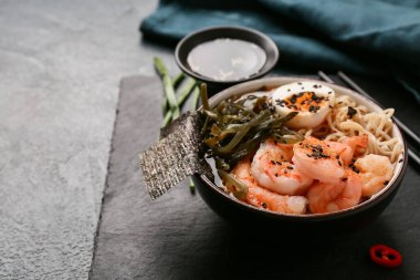 Karidesli erişte çorbası ve arka planda yosun örtüsü, yakın plan.