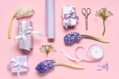 Çiçekli leylak hediye kutuları, ambalaj kağıdı ve pembe arka planda kurdele. Uluslararası Kadınlar Günü