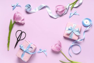 Leylak arka planında lale, kurdele ve makaslı hediye kutularından yapılmış çerçeve. Uluslararası Kadınlar Günü