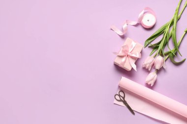 Laleli hediye kutusu, ambalaj kağıdı ve leylak arkaplanlı makas. Uluslararası Kadınlar Günü
