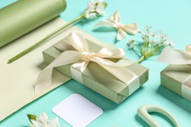 Çiçekli hediye kutuları ve turkuaz arka planda ambalaj kağıtları. Uluslararası Kadınlar Günü