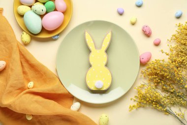 Tabaklarla, çiçeklerle ve bej arka planda Paskalya yumurtalarıyla kompozisyon