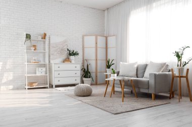 Perde, kanepe ve bitkilerle aydınlık oturma odasının içinde.