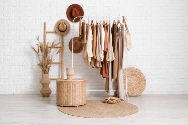 Elbise askılığı, şapkası ve merdiveni olan butiğin içi.