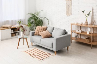 Rahat kanepe ve vazoda bambu saplı hafif oturma odasının şık bir iç mekanı.