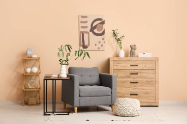 Rahat koltuğu, bambu sapı ve kitapları olan modern oturma odasının şık bir iç mekanı.