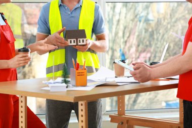 Ofiste çalışan ev modelli bir inşaat ekibi.