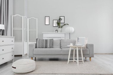 Gri kanepeli, masalı ve katlanır perdeli oturma odasının içi.