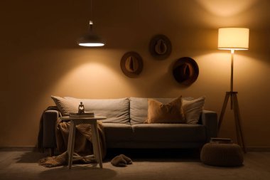 Akşamları kanepe, şapka ve parlayan lambalarla dolu karanlık oturma odasının içinde.