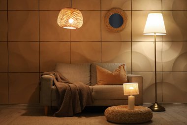 Kanepe, puf ve gece lambaları olan oturma odasının içinde.