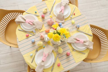 Yemek odasında çiçekler ve paskalya yumurtaları olan güzel bir masa.
