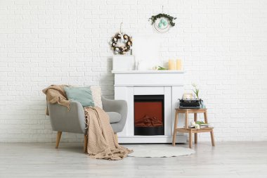 Paskalya için dekore edilmiş oturma odasının içinde koltuk, şömine ve tabure var.