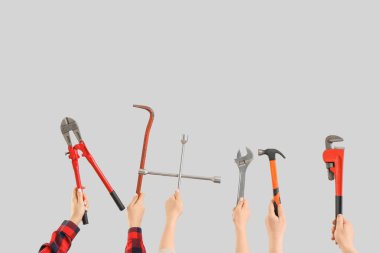 Işık arkaplan üzerinde inşaat araçları ile çok sayıda el