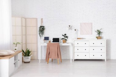 Çalışma alanı, katlama ekranı ve klozeti olan ofis içi