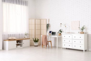 Çalışma alanı, katlama ekranı ve bitkileri olan ofis içi