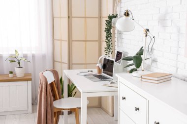 Çalışma alanı, katlama ekranı ve bitkileri olan ofis içi