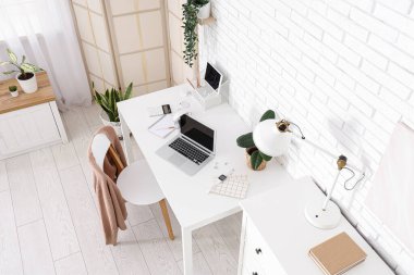 Çalışma alanı, katlama ekranı ve bitkileri olan ofis içi