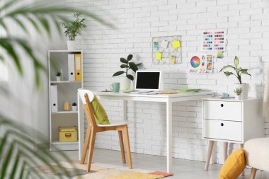 Çalışma yeri ve raf ünitesi olan tasarımcı ofisinin içi