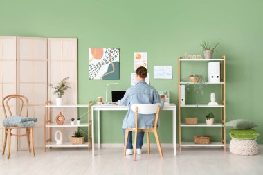 Ofisteki masada dizüstü bilgisayarla çalışan genç bir kadın.