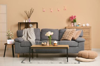 Paskalya için dekore edilmiş oturma odasının içi kanepe ve masalarla dolu.