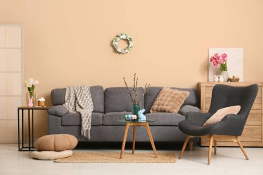 Paskalya için dekore edilmiş oturma odasının içi kanepe, koltuk ve masalarla dolu.