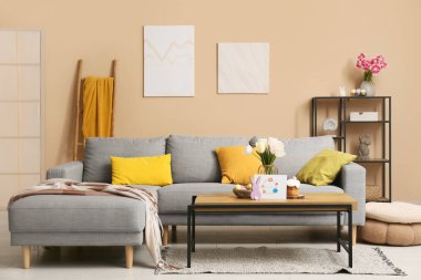 Paskalya için dekore edilmiş oturma odasının içinde kanepe, masa ve raf ünitesi var.