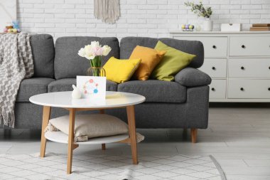 Paskalya için lale ve kartla dolu vazo oturma odasındaki masada.