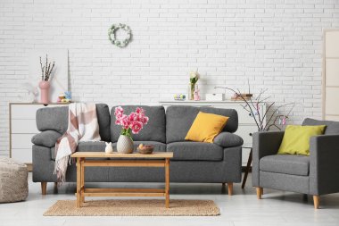 Paskalya için dekore edilmiş oturma odasının içinde kanepe, koltuk ve masa var.