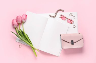 Çiçekli, çantalı ve pembe arka planda mücevherleri olan boş moda dergisi. Bahar mevsimi konsepti
