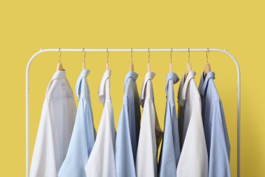 Sarı arka planda şık yakalı gömlekler.