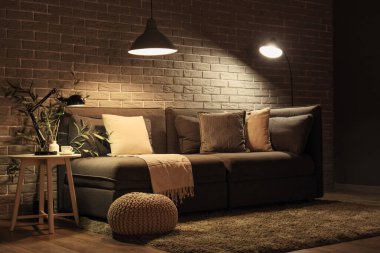 Rahat kanepesi, puf ve parlak lambaları olan şık bir oturma odası.