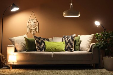 Rahat kanepesi, dekoratif ağacı ve parıldayan lambaları olan şık bir oturma odası.